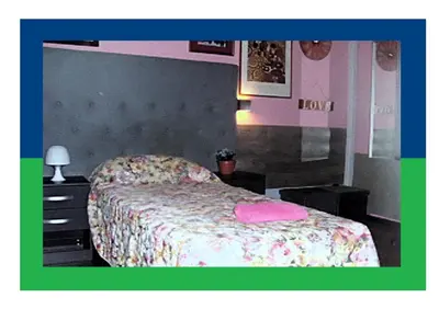 a room with a table and a red chair and a bed at Santa Oliva Homestay in Palermo