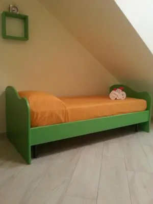 a green bed with an orange blanket in a room at Villa Iris in Castellammare del Golfo
