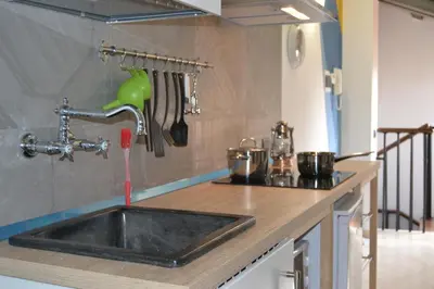 a kitchen sink with a faucet with water coming out at Appartamento Delle Pergole in Palermo