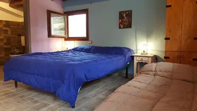 a bedroom with a large blue bed and a couch at Casolare La Torre in Scopello