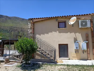 a building with a staircase and a sign on it at Casolare La Torre in Scopello