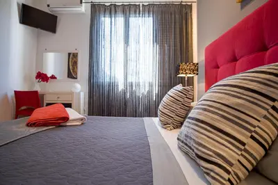 a bedroom with a large bed with a red headboard at Le Muse Mondello in Mondello