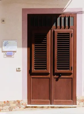 a wooden door with windows on a building at Il Glicine Appartamenti & Rooms in Castellammare del Golfo