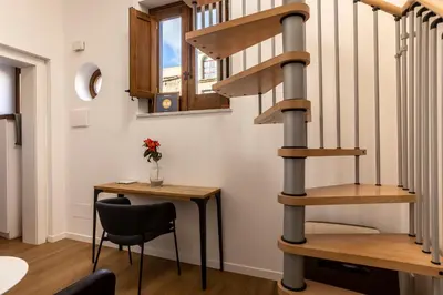 a spiral staircase in a room with a table and a chair at Vespri Apartments in Palermo