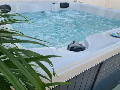 a hot tub with blue water and a plant at casa sul mare in Terrasini
