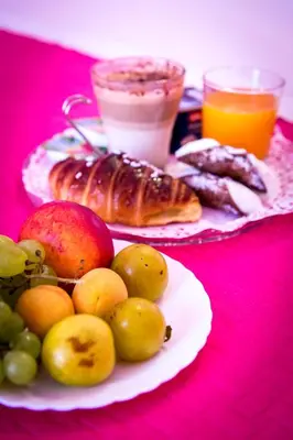 a table with a plate of fruit and other foods at Colors B&B in Palermo