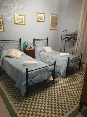 two twin beds in a room with at Casa nobiliare in Palermo