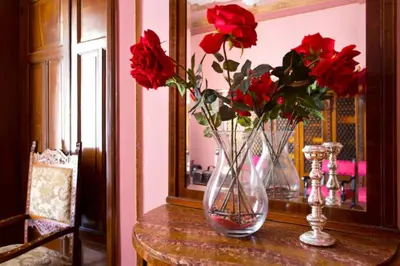 two vases with red roses inront of a mirror at Casa nobiliare in Palermo