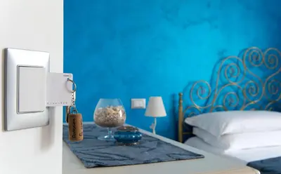 a blue bedroom with a bed and a table with a wine glass at I Segreti di Antonina in Castelluzzo