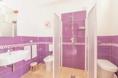 a purple bathroom with a sink and a toilet at I Segreti di Antonina in Castelluzzo