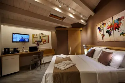 a hotel room with a bed and a desk and a television at Hospitality Hotel in Palermo