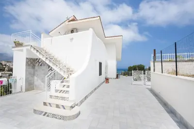 a white house with stairs on a balcony at Villa Trinacria Apartments in Alcamo Marina