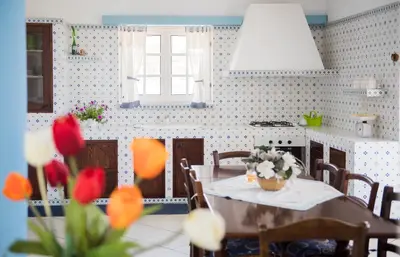 a kitchen with a table with flowers on it at Villa Trinacria Apartments in Alcamo Marina