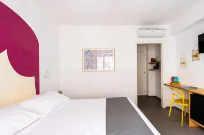 a bedroom with a bed and a desk with a computer at Pretoria Rooms in Palermo