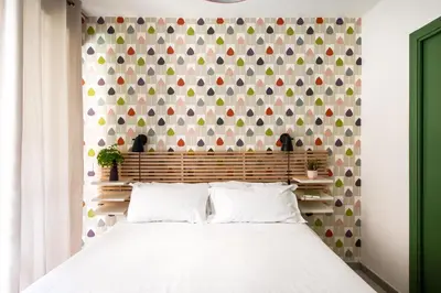 a bedroom with a white bed with a colorful wall at Pretoria Rooms in Palermo