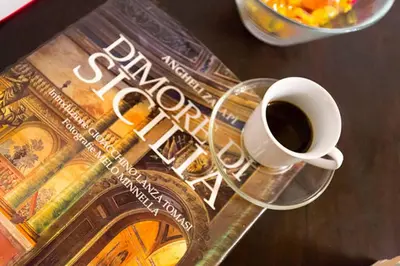 a cup of coffee sitting on top of a book at Casakameusa in Palermo