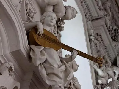 a statue of a woman holding a guitar on a building at Casakameusa in Palermo
