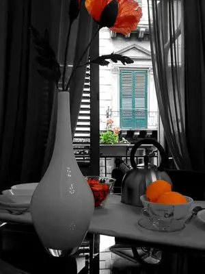 a white vase sitting on top of a table with oranges at Casakameusa in Palermo