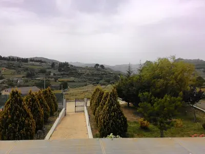 a row of trees with mountains in the background at Il Noce Antico in Bisacquino