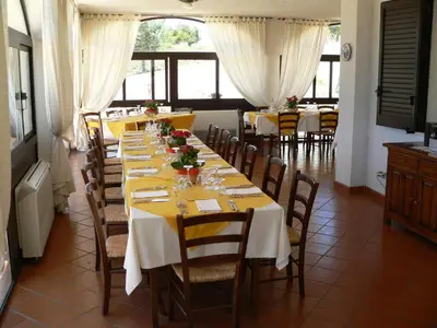 a dining room with tables and chairs with flowers on them at Il Noce Antico in Bisacquino