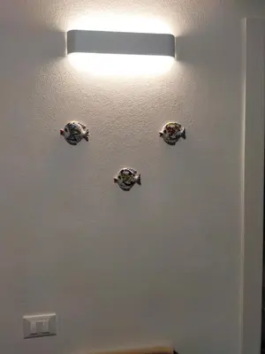 a light on a wall with four plates on it at Casa Vacanze Playa 54 in Castellammare del Golfo