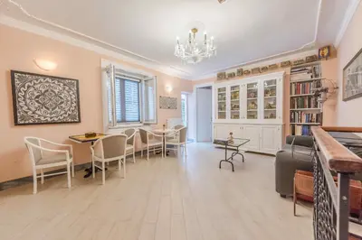 a living room with chairs and tables and a chandelier at Palazzo Benso in Palermo