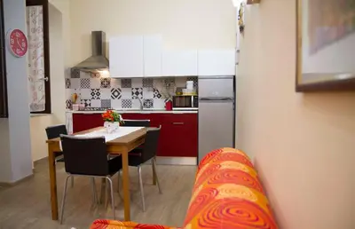 a kitchen with a table and a kitchen with a couch at Le Case Moncada in Palermo