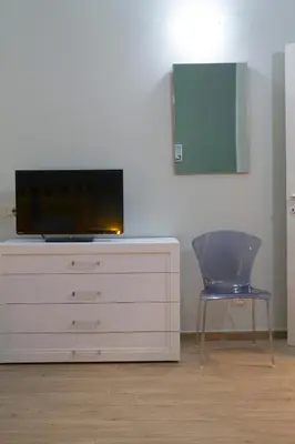 a tv sitting on top of a dresser with a chair at Le Case Moncada in Palermo