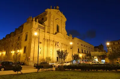 a large building with cars parked in front of it at night at Dimora Torremuzza in Palermo