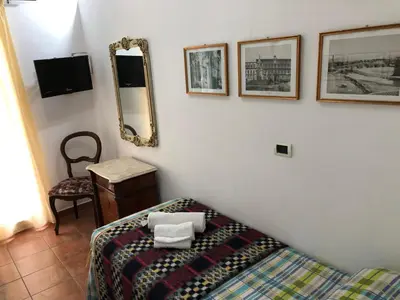 a bedroom with a bed and a mirror and a chair at Bahalara Alloggio in Palermo