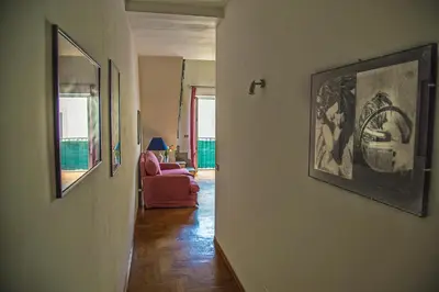 a hallway with a living room with a couch and pictures on the wall at Palazzo Trinacria in Palermo