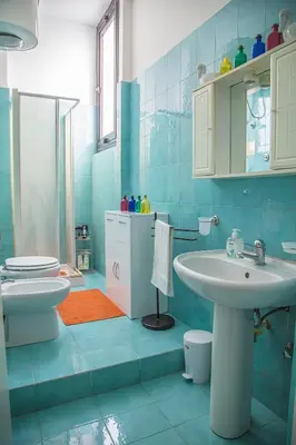a blue bathroom with a sink and a toilet at Palazzo Trinacria in Palermo