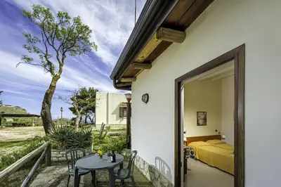 a bedroom with a bed and a table and chairs at Agriturismo Finazzo in Balata di Baida