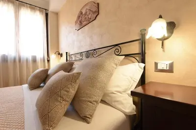 a bedroom with a bed with pillows and a lamp at Bed & Breakfast Goccia Marina in San Vito lo Capo