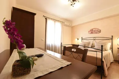 a bedroom with a bed and a table with a vase of flowers at Bed & Breakfast Goccia Marina in San Vito lo Capo