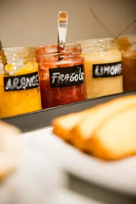 a row of jars of mustard and jam with a sandwich at La Meridiana in Castellammare del Golfo