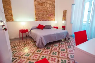 a bedroom with a bed and two red tables at B&B L'Orlando Furioso in Palermo