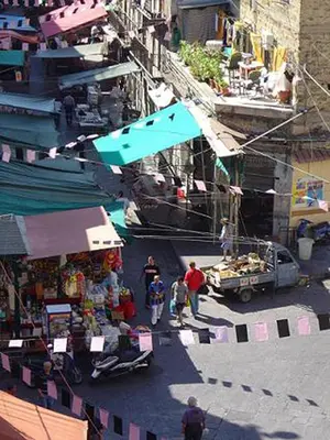 a group of people walking around a market with a truck at Hotel Cortese in Palermo
