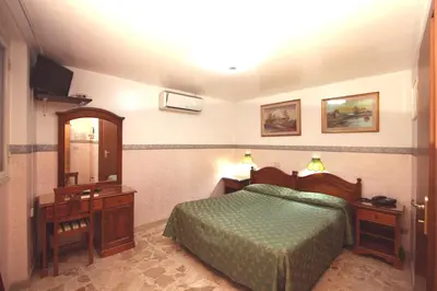 a bedroom with a bed and a dresser and a mirror at Hotel Cortese in Palermo