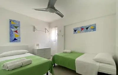 a bedroom with two beds and a ceiling fan at Maresole apartments - direttamente sul mare in Alcamo Marina