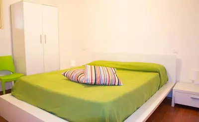 a green bed with a pillow on top of it at Maresole apartments - direttamente sul mare in Alcamo Marina