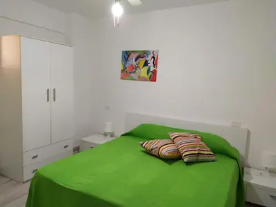 a bedroom with a green bed with two pillows on it at Maresole apartments - direttamente sul mare in Alcamo Marina