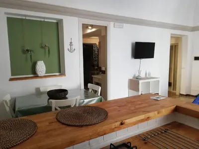 a living room with a wooden table and a television at Fiori d'Arancio in Terrasini