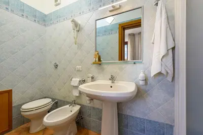 a bathroom with a sink and a toilet and a mirror at Sun Garden in San Vito lo Capo