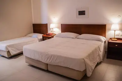 a hotel room with two beds and two lamps at Hotel Mediterraneo in Palermo