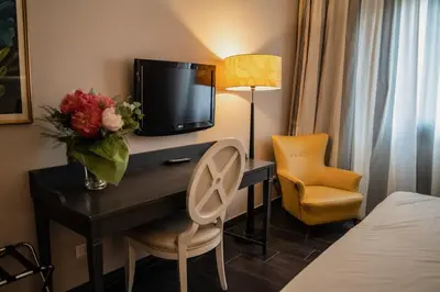a hotel room with a desk with a television and a bed at Hotel Mediterraneo in Palermo