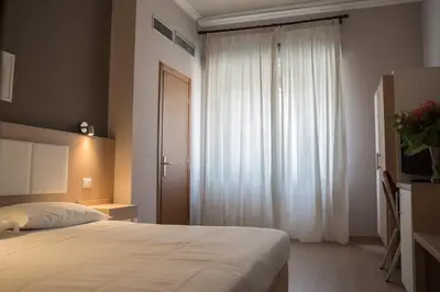 a bedroom with a bed and a large window at Hotel Mediterraneo in Palermo