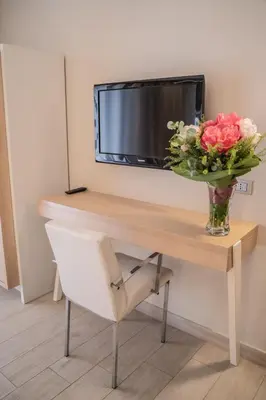 a vase of flowers on a desk with a vase of flowers at Hotel Mediterraneo in Palermo