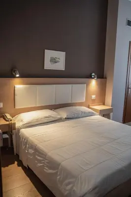 a large white bed in a bedroom with two tables at Hotel Mediterraneo in Palermo