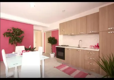 a kitchen with a white table and a pink wall at Rainbow in Castellammare del Golfo